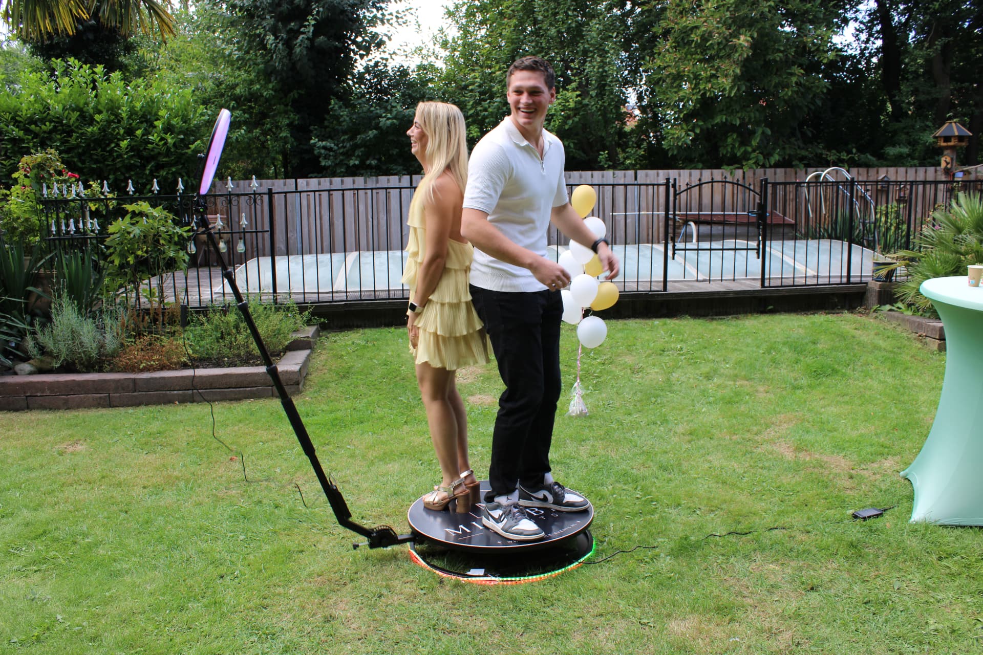 Twee gasten op het 360 spinner platform tijdens een tuinfeest