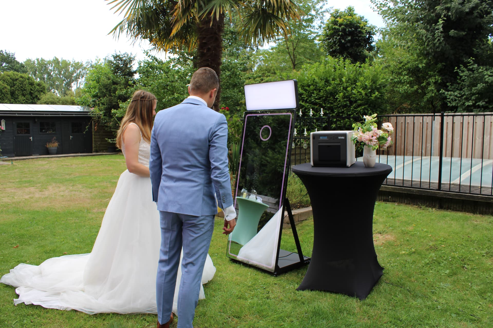 Bruidspaar bij de spiegel-photobooth met printer tijdens hun bruiloft